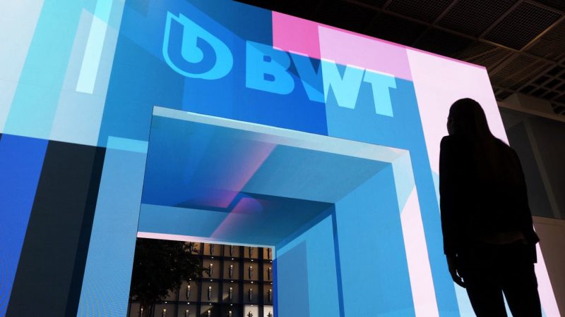 Silhouette of a visitor in front of the digitally animated entrance portal of the BWT trade fair booth