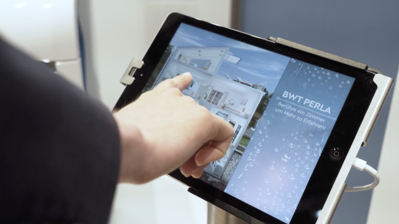 Finger tippt auf ein Zimmer im Touch-Interface BWT Perla des mobilen Showrooms