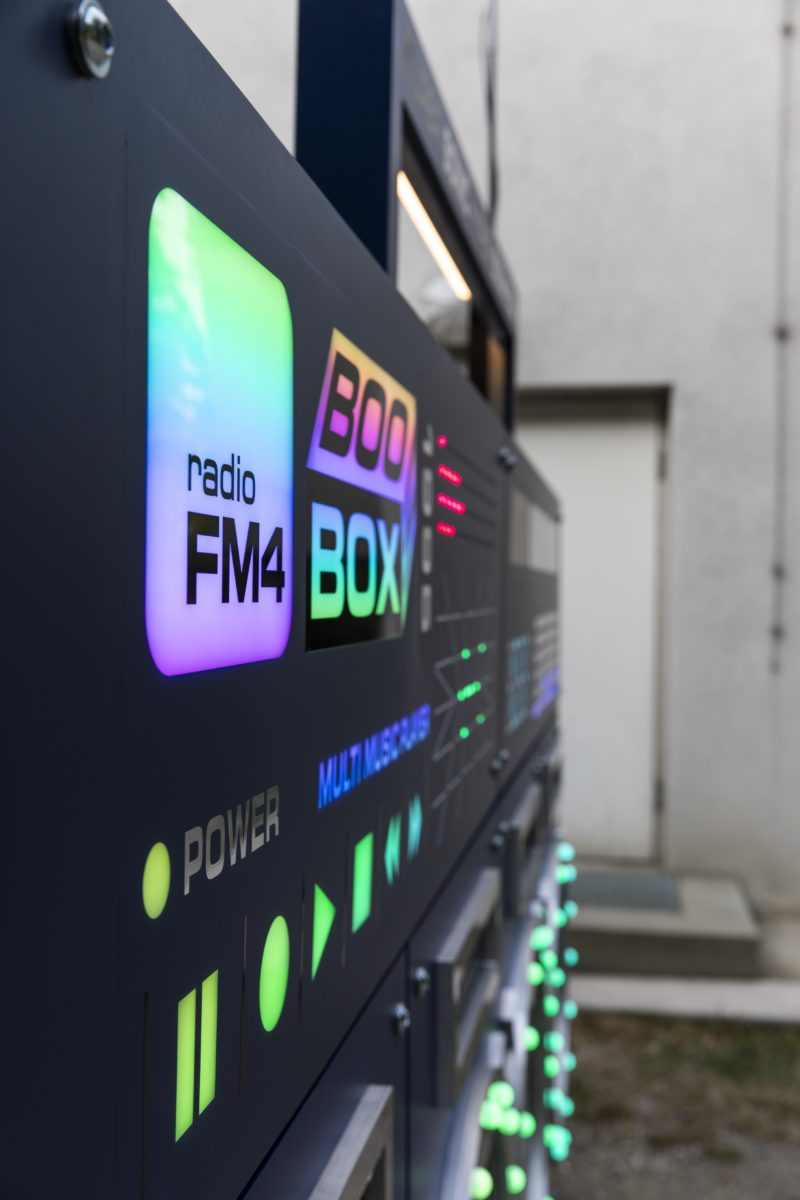 Radio FM4 logo and control buttons on the boombox glowing in shifting RGB colours
