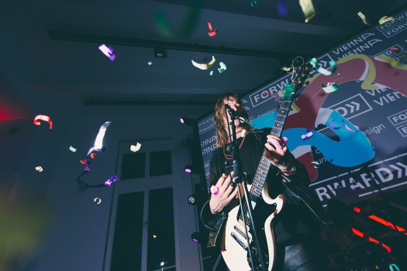 Live-Auftritt mit Gitarre und Konfettiregen vor der Festivalprojektion