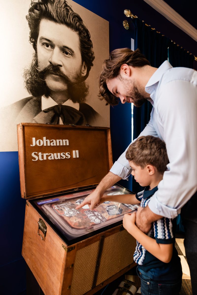 Man and child exploring the touchscreen inside Johann Strauss II’s digital suitcase