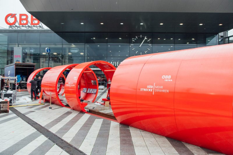 Rote Tunnelmodule mit Schriftzug ÖBB Infra beim Aufbau vor dem Eingang des Wiener Hauptbahnhofs