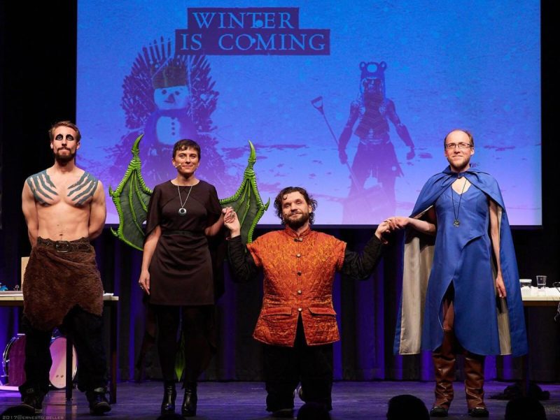 Science Busters cast in Game of Thrones costumes on stage in front of a Winter is Coming projection