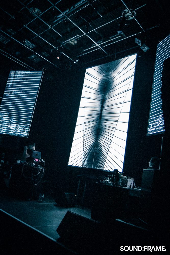 AV gig with three portrait projection screens showing black-and-white line visuals