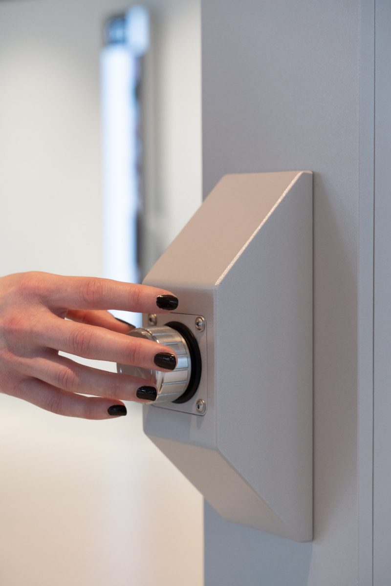 Hand turning the haptic rotary dial mounted on one of the pillars at VISTA Science Experience Center