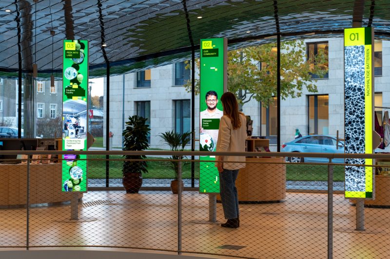 Visitor at the “Our Community” pillar next to “Peek Inside the Labs”, both in a green layout