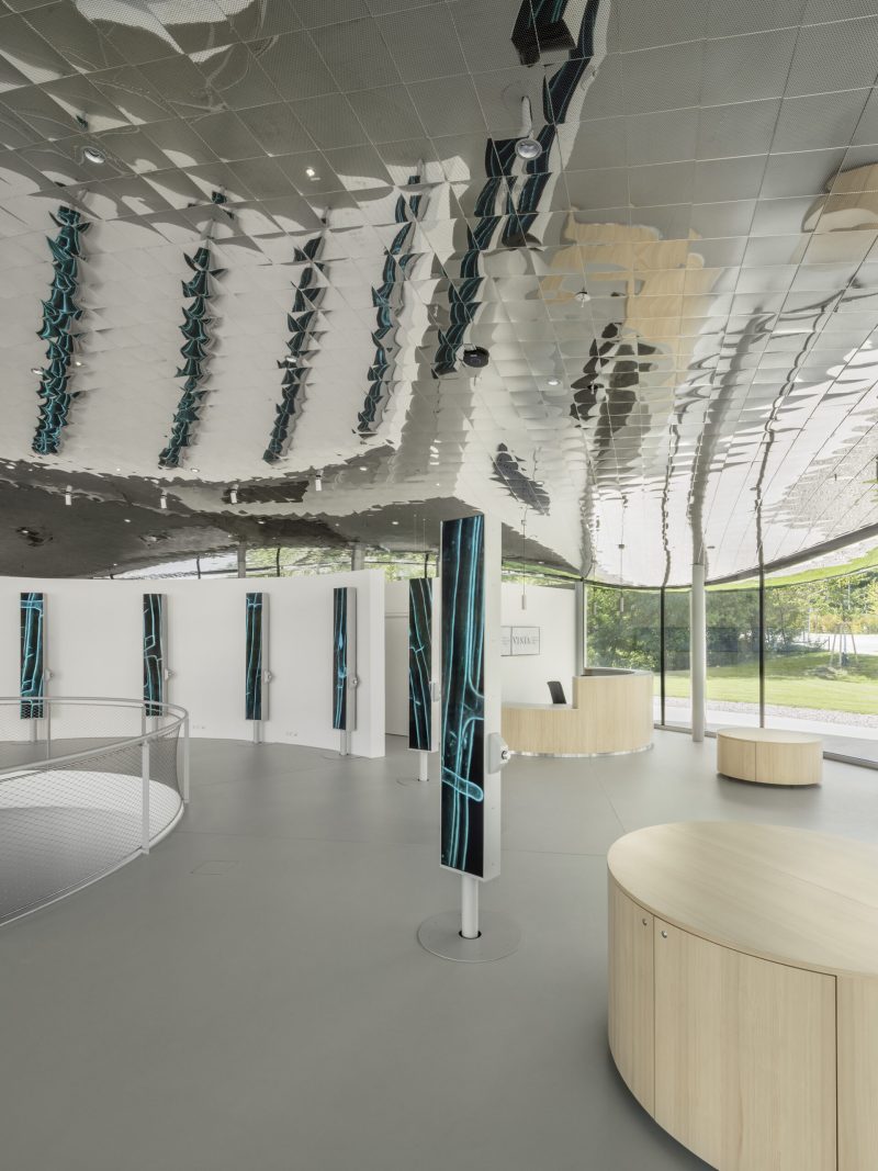 Pillars showing blue-green visuals in the bright foyer, with the VISTA reception desk behind