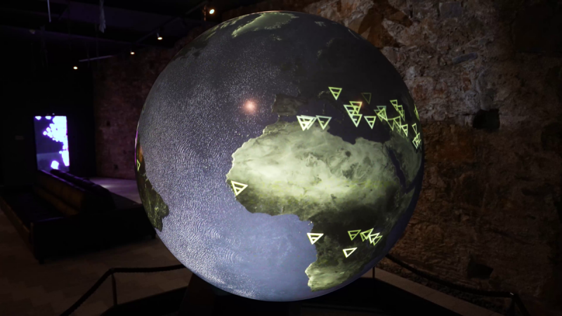 Glowing globe with green triangle markers as data points over Europe and Africa, video still