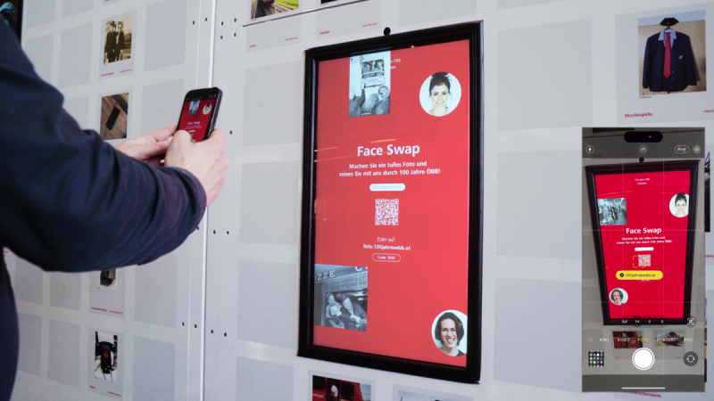 Visitor scans the QR code at the face-swap station with a smartphone to appear in historic ÖBB photos